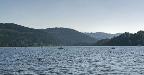 Scenic view of lake and mountains against clear sky