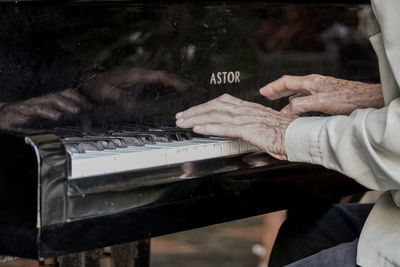 Close-up of man playing piano