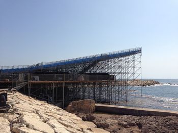View of built structure by sea against clear sky