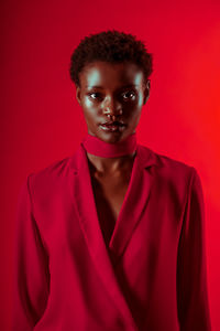 Young women standing against red background