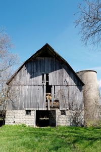 Old barn on field against clear sky