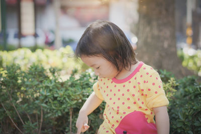 Close-up of cute girl looking at plants