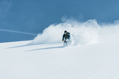 People skiing on snow covered landscape