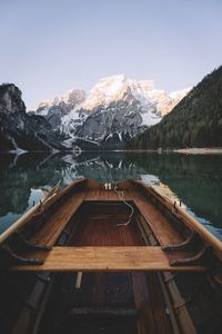 Wooden boat in river against mountain