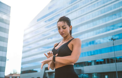 Low angle view of woman standing on mobile phone