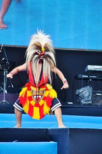 Full length of woman standing against wall