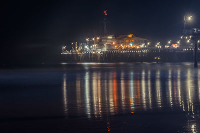 Illuminated sea against sky at night