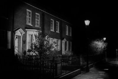 Illuminated building by street at night
