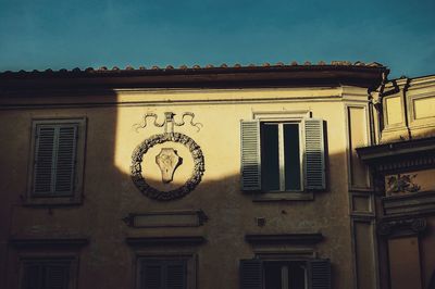 Low angle view of clock on building against sky