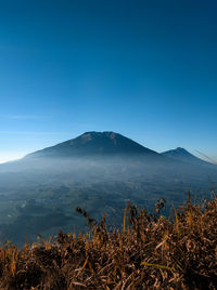 Scenic view of mountains against clear blue sky