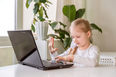 The girl learns, communicates, talks, through a computer / laptop