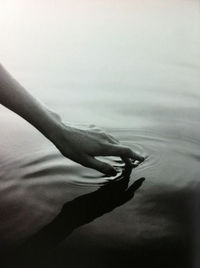 Close-up of hands over water against white background