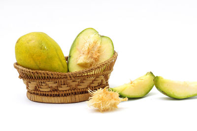 Close-up of fruits in basket against white background