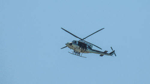 Low angle view of airplane against clear blue sky