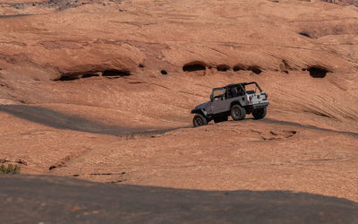 Full frame view of a jeep on a 4x4 trail on sandstone in rugged terrain on a sunny day