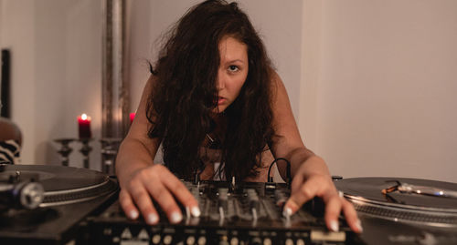 Close-up of fashionable young woman playing music at home