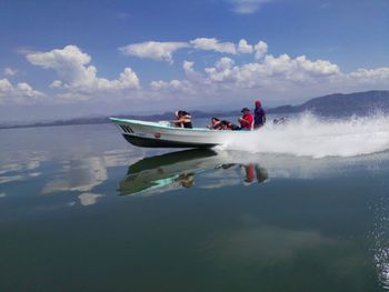 People on boat against sky