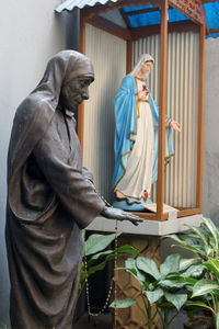 Statue of buddha against window