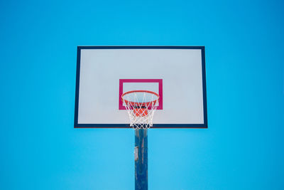 Low angle view of basketball hoop against blue sky