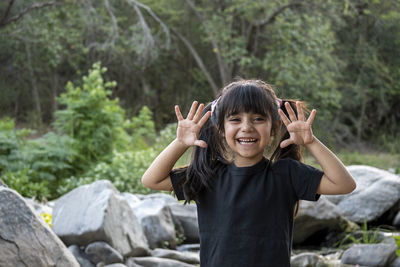 Portrait of smiling young woman sitting on rock