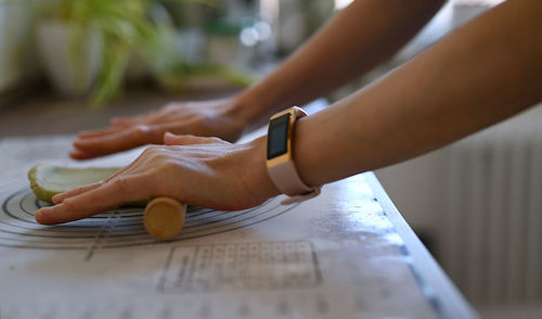 Close-up of person rolling out dough