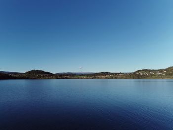 Scenic view of lake against clear blue sky