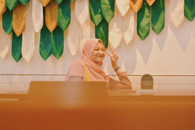 Portrait of a smiling beautiful young woman with scraft sitting on chair