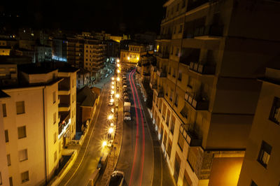 High angle view of illuminated street amidst buildings at night