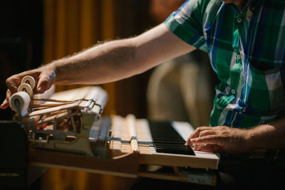 Midsection of pianist playing piano