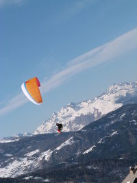 Person skiing on snowcapped mountain against sky