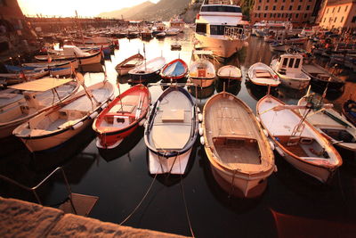 Boats moored in river at harbor on sunny day