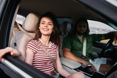 Portrait of smiling friends sitting in car