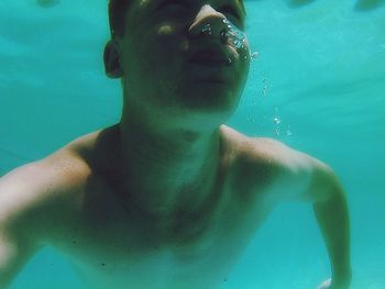 Portrait of young man swimming in pool