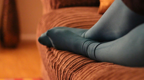 Low section of woman relaxing on sofa