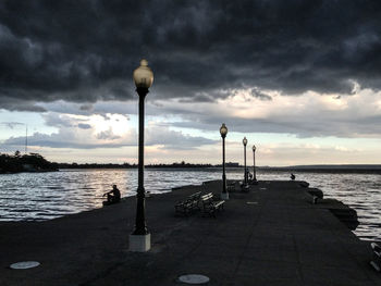 Street light by sea against sky