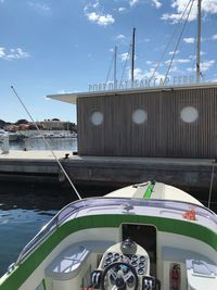 Sailboats moored at harbor against sky