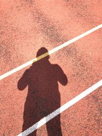 Shadow of man on sports track