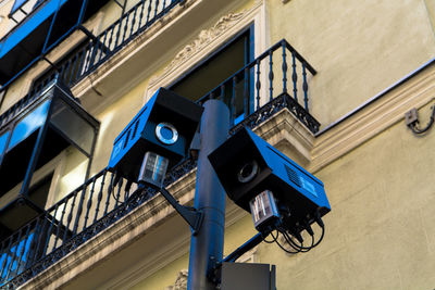 Low angle view of security cameras against building in city