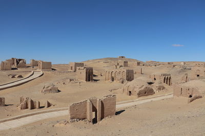 Built structure on desert against blue sky