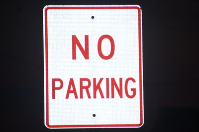 Close-up of warning sign against black background