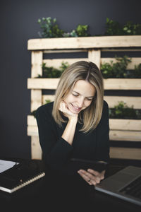 Portrait of smiling young woman using mobile phone