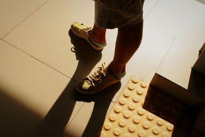 Low section of person standing on tiled floor