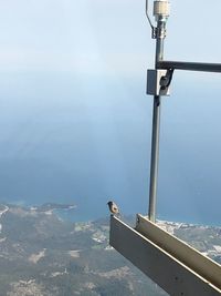 High angle view of railing by sea against sky