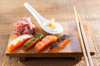 High angle view of sashimi with chopsticks on table