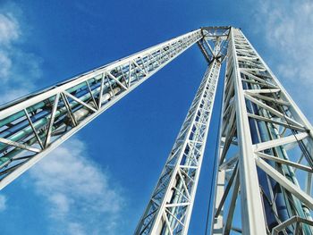 Low angle view of free falling ride against blue sky on sunny day