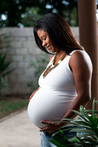 Side view of pregnant woman standing outdoors