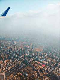 Aerial view of buildings in city against sky