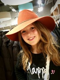 Portrait of smiling cute girl wearing hat at store