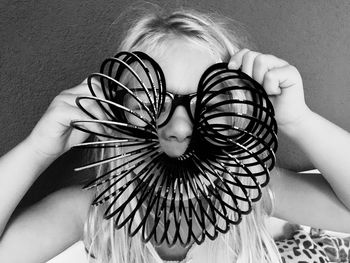 Close-up of girl holding toy against wall