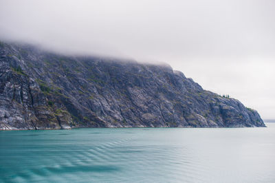 Scenic view of sea and mountains against sky